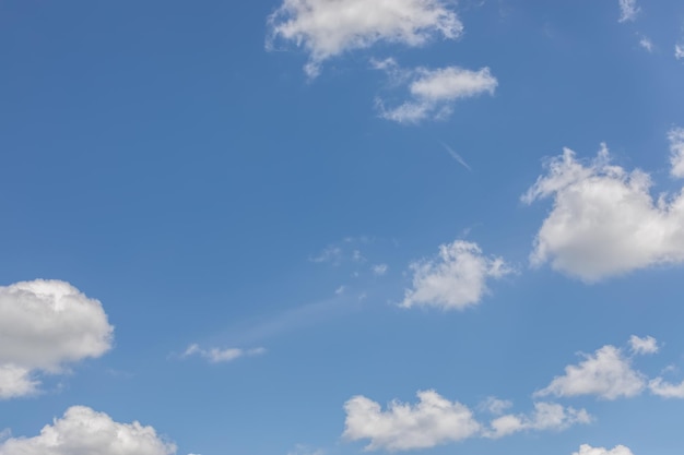 Esponjosas nubes blancas aisladas en un cielo azul pálido del mediodía de verano espacio de copia de fondo ideal