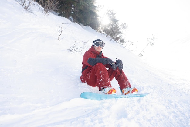 Esporte de lazer de inverno e conceito de pessoas snowboarder fica no alto das montanhas na beira da encosta e olha para a distância