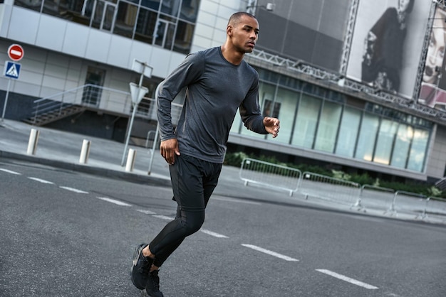 Esporte é minha motivação retrato de corpo inteiro de homem atlético africano em roupas esportivas fazendo todos os dias