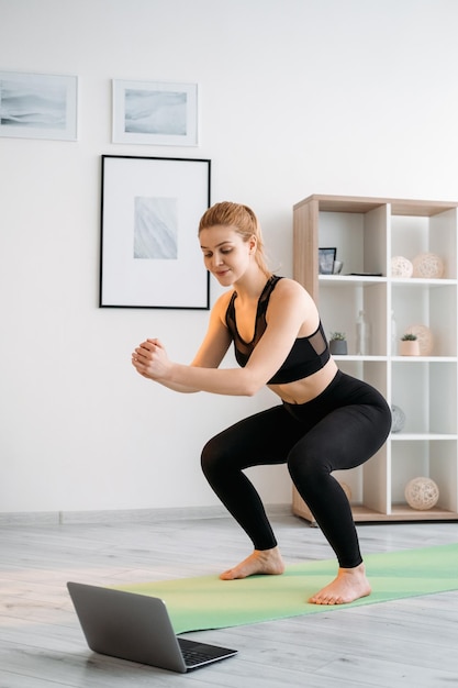 Esporte em casa exercício de laptop de mulher de ginástica virtual