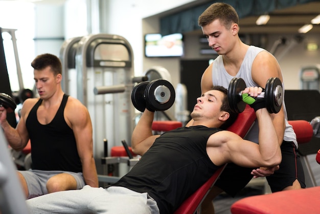 esporte, fitness, estilo de vida e conceito de pessoas - grupo de homens com halteres no ginásio