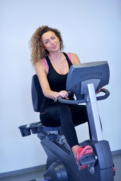 Esporte, fitness, estilo de vida, tecnologia e conceito dos povos - mulher de sorriso que exercita na escada rolante no gym