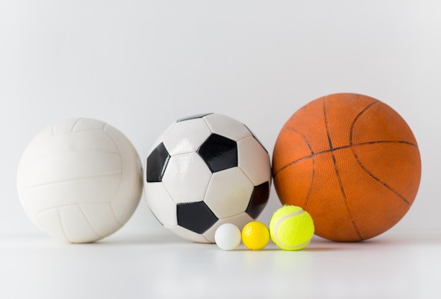 Foto esporte, fitness, jogo, equipamentos esportivos e conceito de objetos - close-up de diferentes conjuntos de bolas esportivas