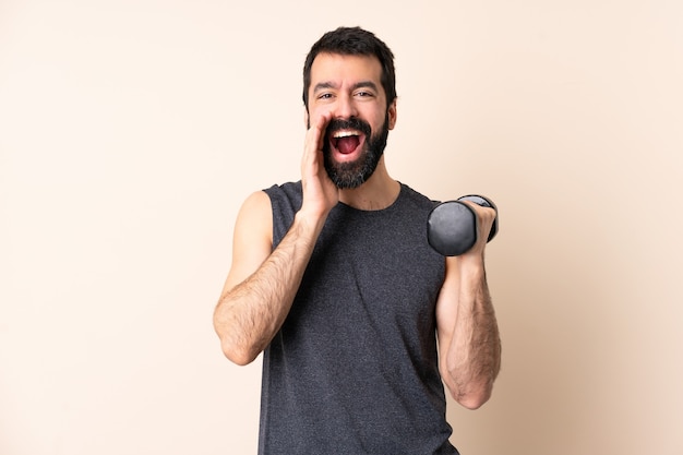 Esporte homem caucasiano com barba fazendo halterofilismo sobre fundo isolado gritando com a boca bem aberta