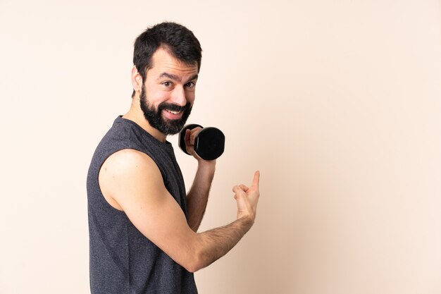 Esporte homem caucasiano com barba fazendo levantamento de peso isolado