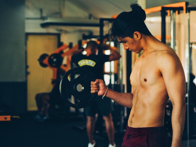 Esporte homem com musculação na aptidão.