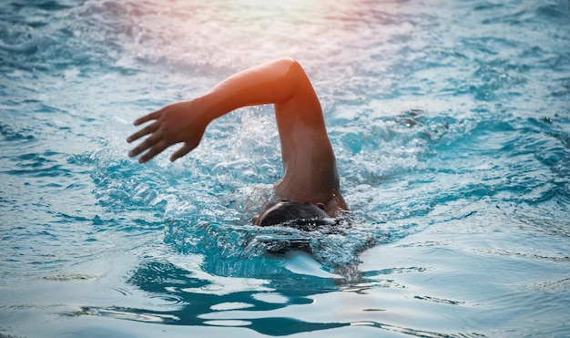Esporte homem nadador triatlo fitness atleta treinamento nadando na piscina de ondas no centro de saúde do ginásio homem nadador nadando no panorama de bandeira de água azul esporte e fitness exercício cardio