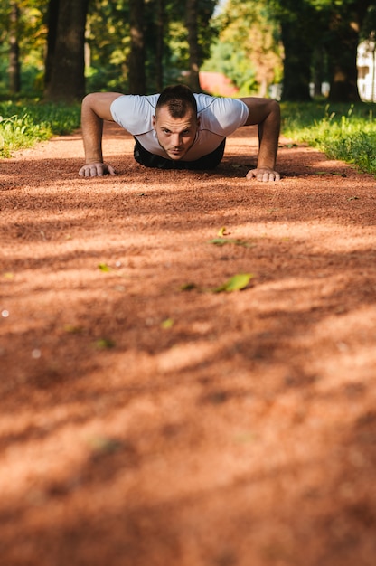 Foto esporte homens fazendo flexões durante treino cruzado ao ar livre no parque