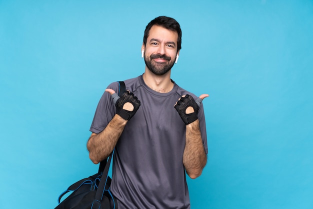 Esporte jovem homem com barba sobre azul com polegares para cima gesto e sorrindo