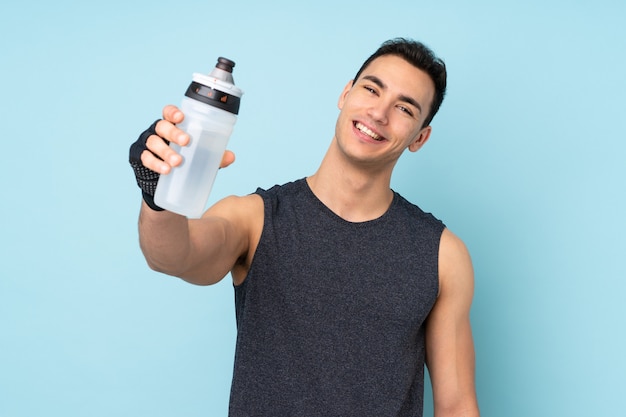 Esporte jovem homem sobre azul com garrafa de água de esportes