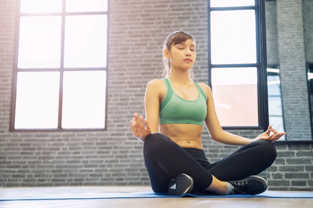 Esporte jovem mulher fazendo pose de ioga no ginásio