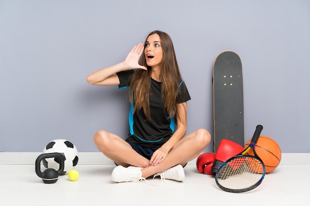 Foto esporte jovem mulher sentada no chão gritando com a boca aberta