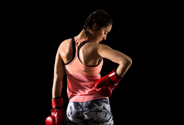 Esporte mulher em fundo escuro com luvas de boxe