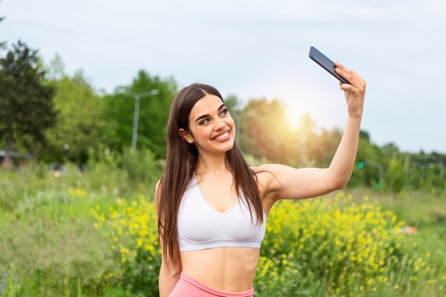 Esporte mulher sorriso na câmera auto-retrato na rua, jovem imagine-se exercitando fitness