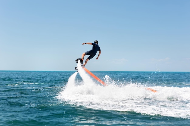 Esporte radical aquático O cara está voando no flyboard aquático Muita pressão da água