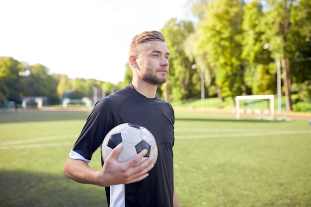 esporte, treinamento de futebol e pessoas - jogador de futebol com bola no campo