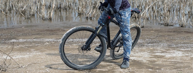 Esportes brutal barbudo em uma mountain bike moderna Um ciclista em um lugar deserto de sal à beira do lago