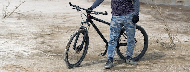 Esportes brutal barbudo em uma mountain bike moderna Um ciclista em um lugar deserto de sal à beira do lago