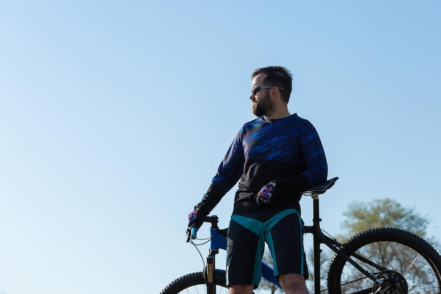 Esportes brutal barbudo em uma mountain bike moderna Um ciclista em um lugar deserto de sal à beira do lago