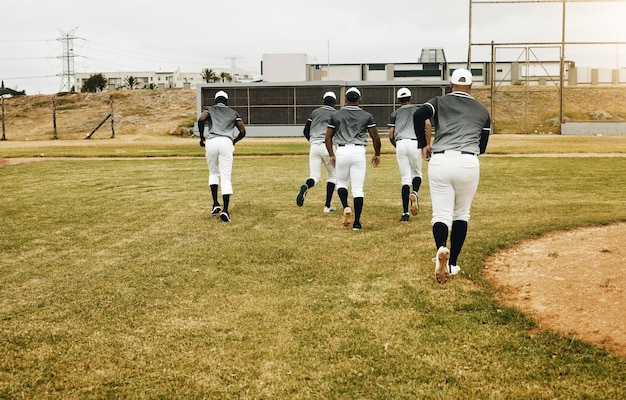 Foto esportes de beisebol e equipe correndo no campo pronto para começar a treinar exercícios físicos e exercícios juntos trabalho em equipe da academia e jovens jogando um jogo na grama ou campo ao ar livre em dallas