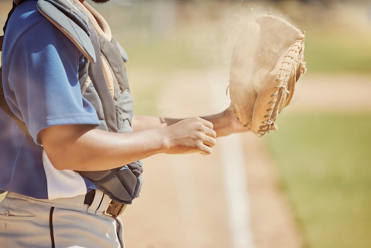 Foto esportes de beisebol e homem com uma bola e luva durante o treinamento de jogo profissional e competição no campo mãos de um atleta pronto para fitness esportivo e cardio no parque natural ou campo
