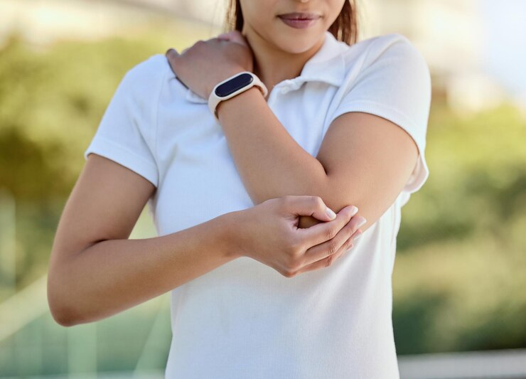 Foto esportes de cotovelo de tenista e uma mulher com lesão fitness e jogo de treinamento na quadra exercício de esporte de treino e menina de tenista de saúde com dor no braço ou acidente de inflamação em partida ao ar livre