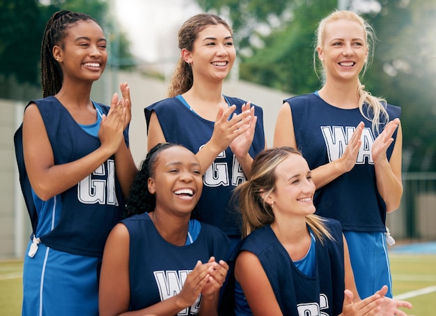 Esportes de netball e equipe feminina aplausos e comemoram a competição do jogo ou treinamento ao ar livre, suporte motivação e trabalho em equipe Grupo de atletas felizes batendo palmas para o gol do vencedor