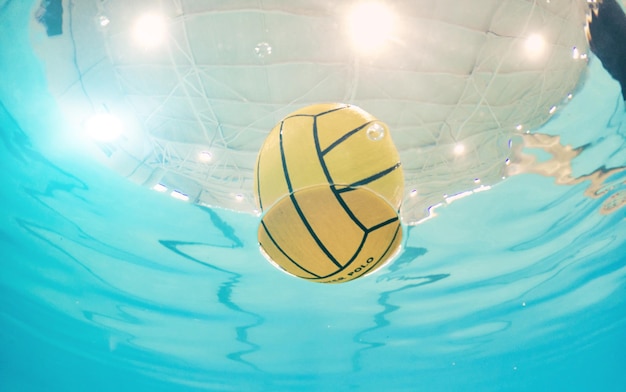 Esportes de pólo aquático e bola em uma piscina de baixo com equipamento flutuando na superfície durante um jogo competitivo Treinamento físico e exercício enquanto um objeto de natureza morta flutua durante uma partida