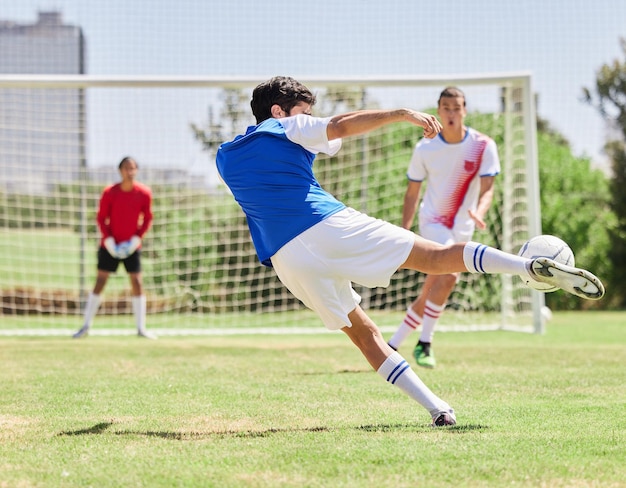 Esportes futebol e atleta marcando um gol durante uma partida ou treinando em um campo ao ar livre em um estádio Futebol fitness e homem saudável praticando para marcar em um jogo para exercício ou treino em campo