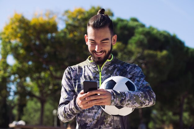 Esportista feliz escrevendo uma mensagem em seu telefone