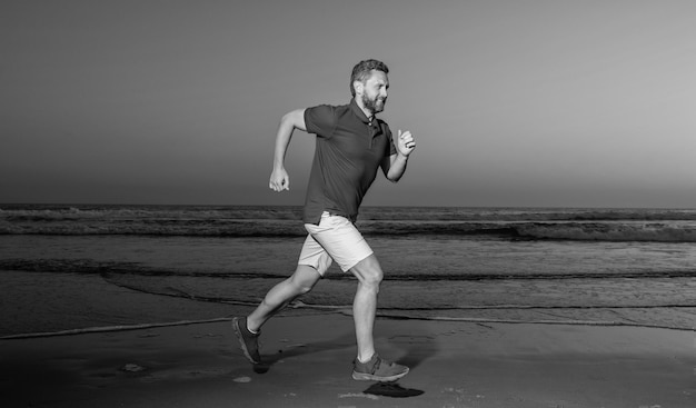 Esportista velocista correndo na praia de verão ao nascer do sol no atleta oceânico