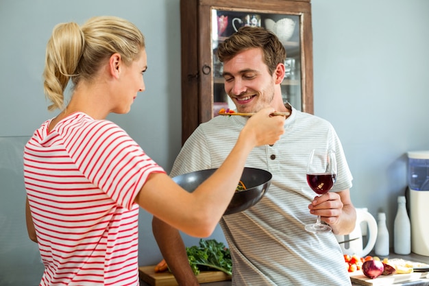 Esposa cocinando con marido en la cocina