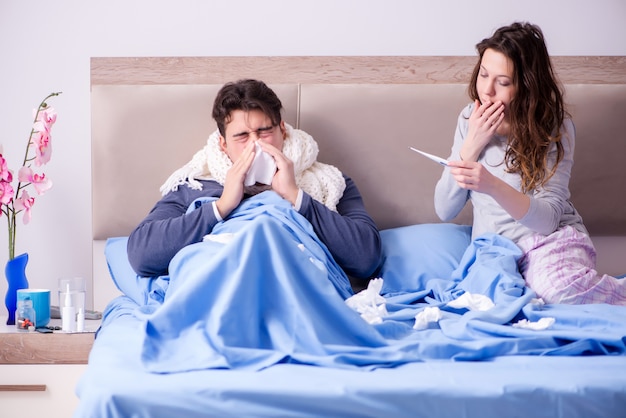 Esposa cuidando esposo enfermo en casa en la cama