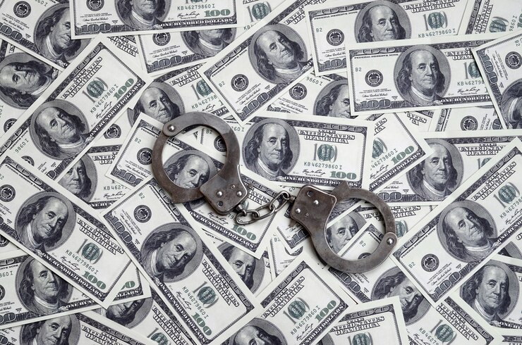 Foto las esposas de la policía se encuentran en un montón de billetes de un dólar.