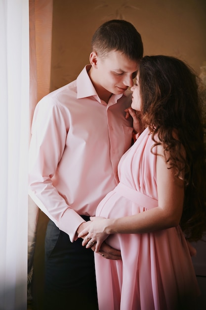 El esposo abraza tiernamente a su esposa embarazada.