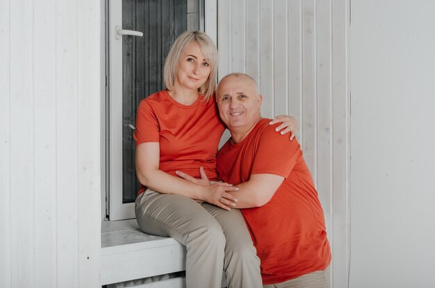 esposo y esposa en camisetas naranjas se abrazan y besan