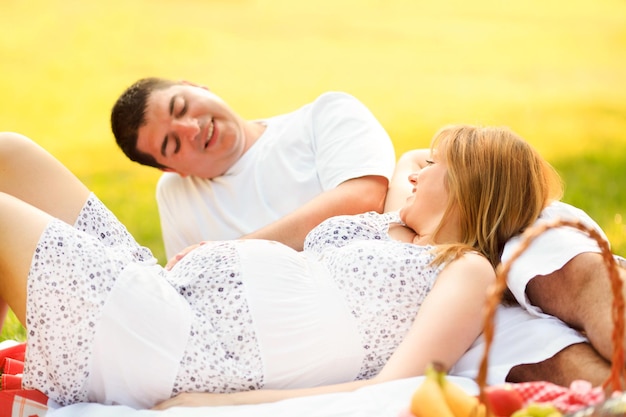 Foto esposo y esposa embarazada relajándose el día de verano en el parque