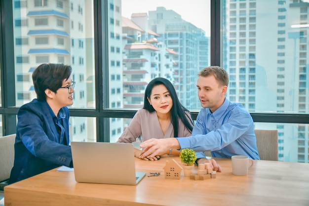 El esposo y la esposa están discutiendo con un vendedor de un condominio residencial.Consultor Comprar una casa y residencia.