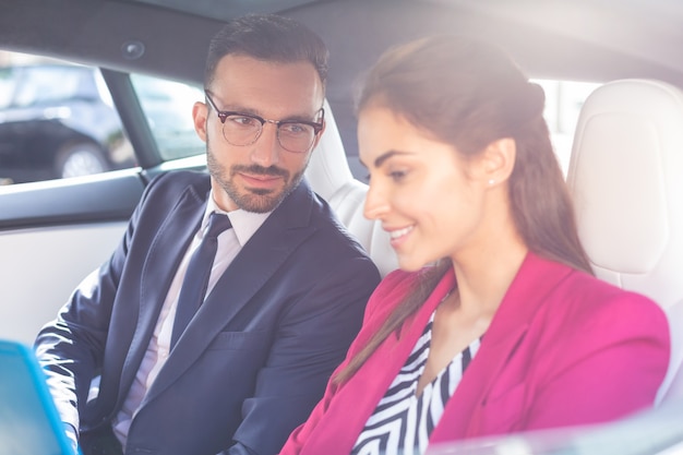 Esposo y esposa. guapo radiante marido y mujer sentados en el asiento trasero del coche