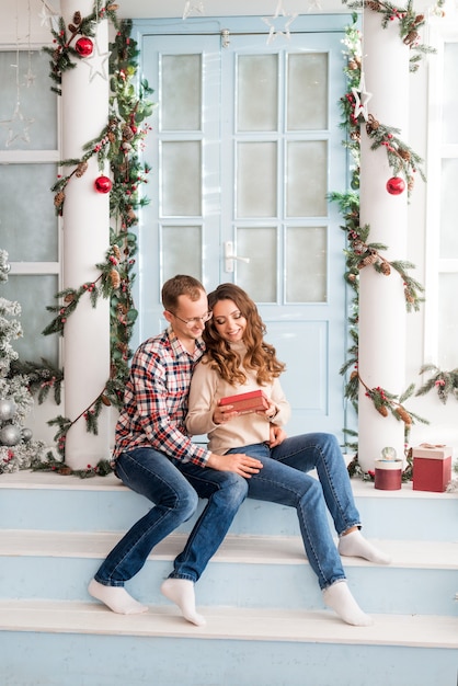 El esposo felicita a su esposa por el año nuevo y la Navidad y le da regalos.