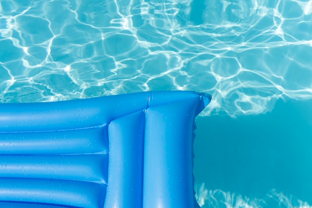 Espreguiçadeira de piscina de verão azul brilhante flutua em uma piscina ondulada