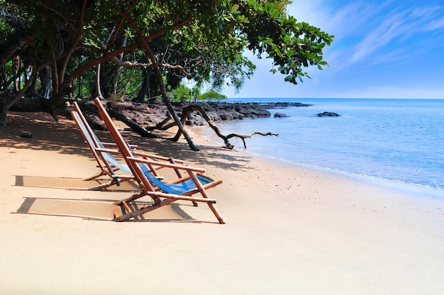 Espreguiçadeiras de bambu na praia com sol brilhante e ondas Ilha ao sul da TAILÂNDIA Dia relaxante na praia