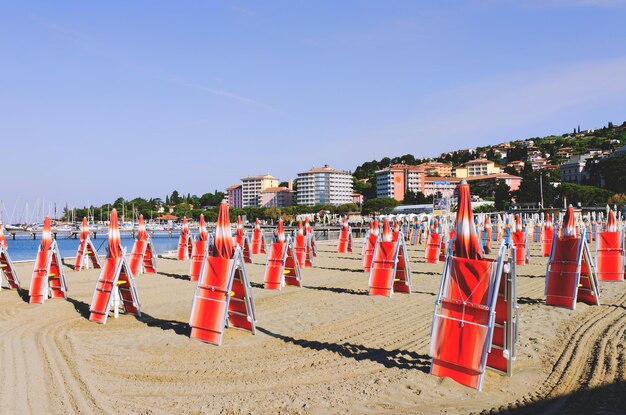 Espreguiçadeiras e guarda-sóis em uma bela praia tropical na costa do Adriático, na Eslovênia. Lazer