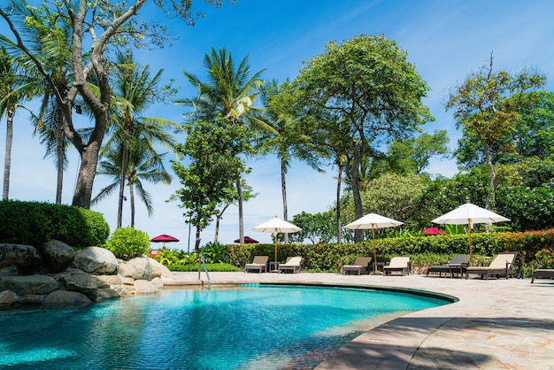 Espreguiçadeiras e guarda-sóis perto da piscina