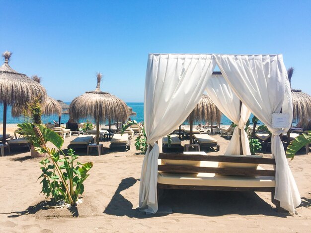 Espreguiçadeiras na costa da praia arenosa no resort mediterrâneo de luxo de verão como destino de viagem e férias