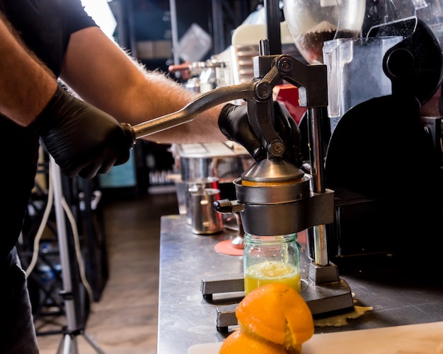 Espremedor manual de metal. Preparação de suco de laranja espremido na hora