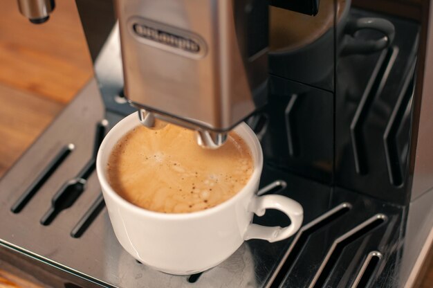 Foto espresso a ser derramado da máquina de café perto de uma cervejaria de café profissional