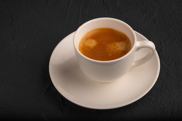 Espresso em uma xícara branca em um fundo escuro