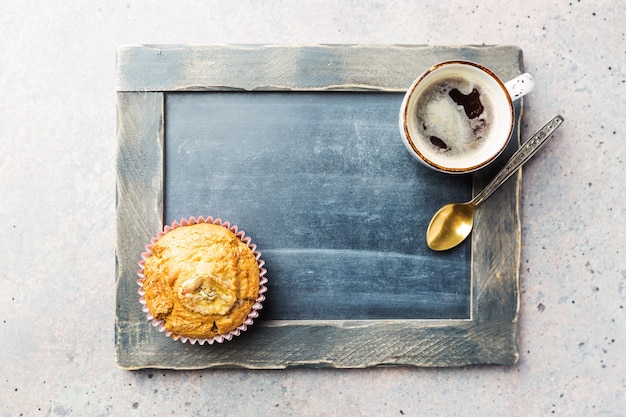 Espresso de estilo clásico con muffin de chip y taza de café en la vista superior de la mesa de piedra gris