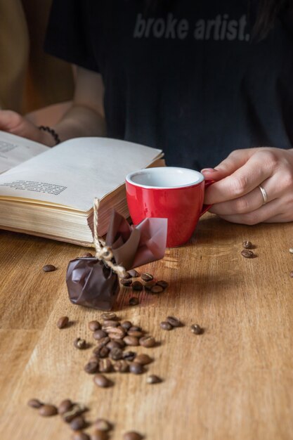 Espresso im roten Tassenbuch und süße Frau, die Kaffee trinkt